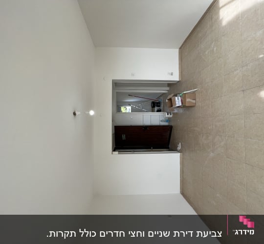 חדר עם קירות צבועים בלבן, סולם וציוד צביעה